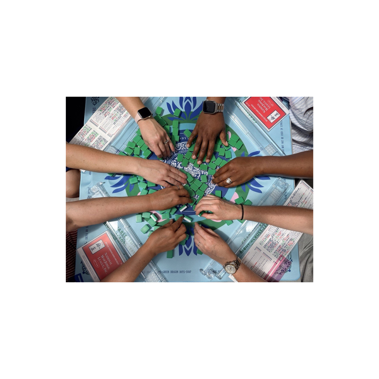 Players gathering tiles at a Gracey Tile Club American Mahjong table