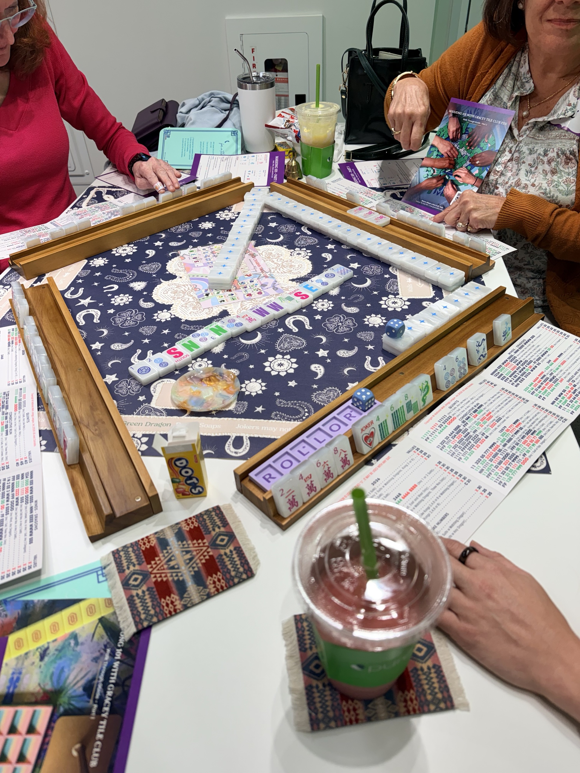 Players going over tiles with the Mahjong 101 walk-through guide
