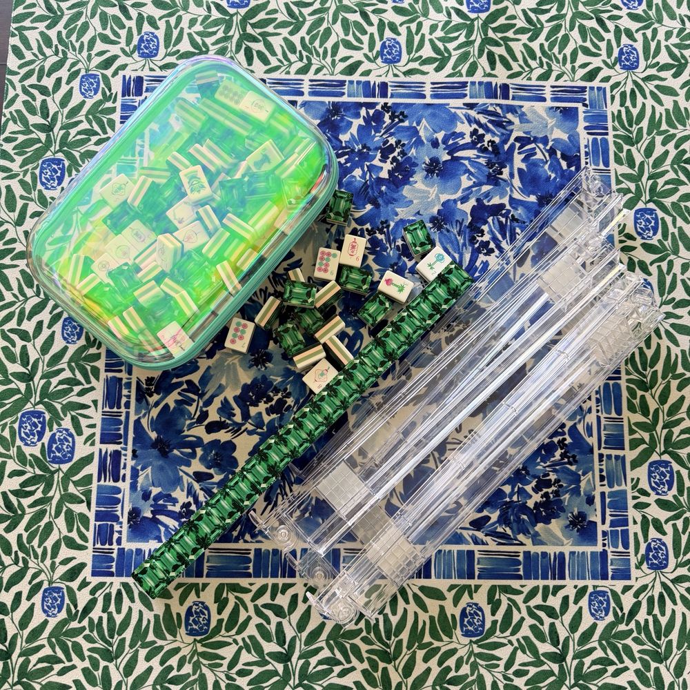 Emerald jewel mahjong tiles with clear racks on a green leaf and blue floral mat